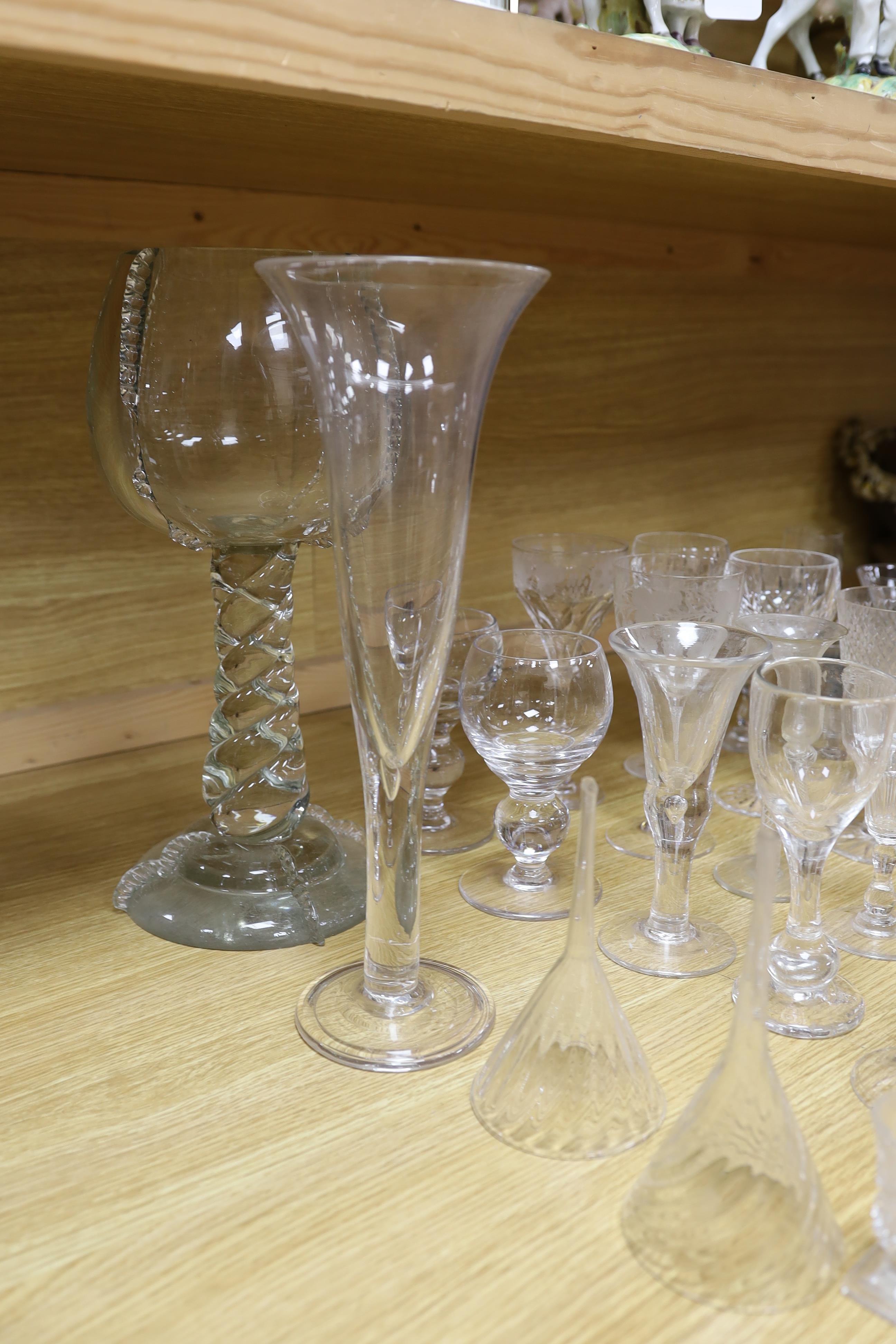 A large glass centrepiece, a teardrop trumpet shaped vase and a collection of 19th and 20th century wine and other drinking glasses